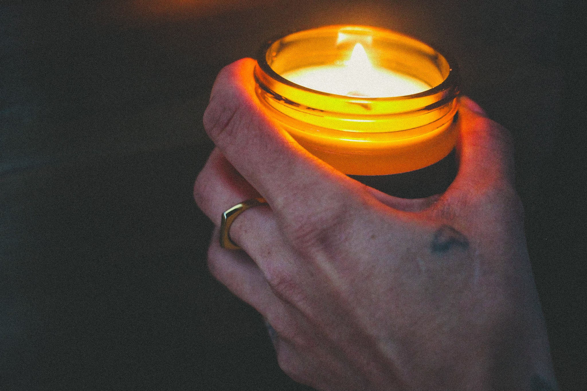 Wooden wick candle burning while being held by Vicki.