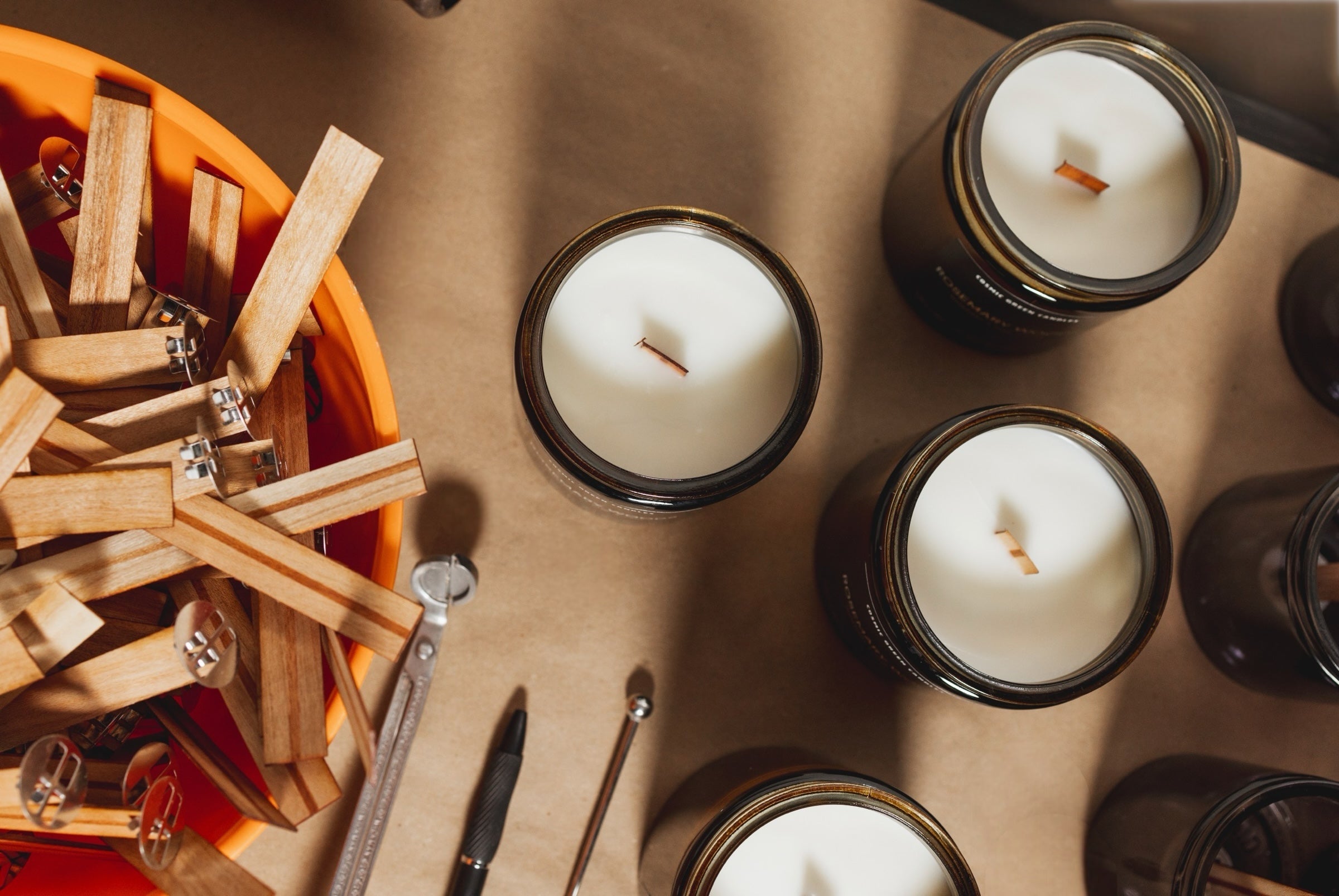 Close-up of wood wicks placed beside a soy wax candle in a amber jar